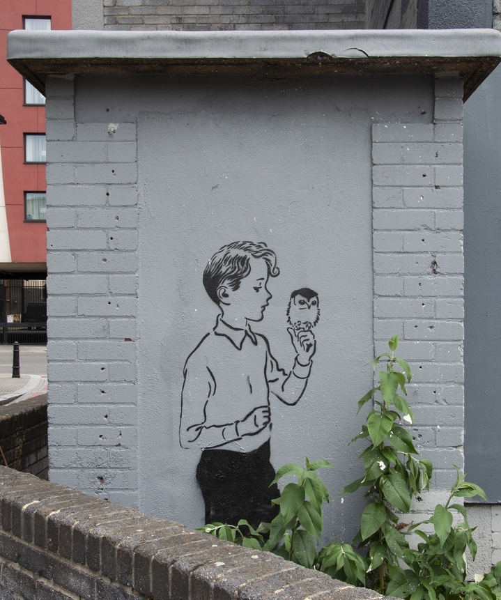 Old School street art stencil of a wholesome looking boy with an wol painted by street artist Pure Evil in Shoreditch in 2010