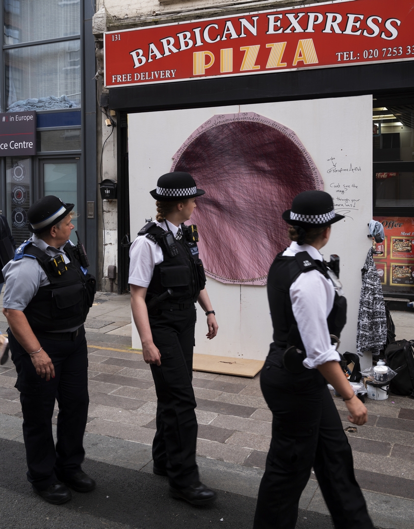 Three policewomen all turn to stare at Perspicere's string art