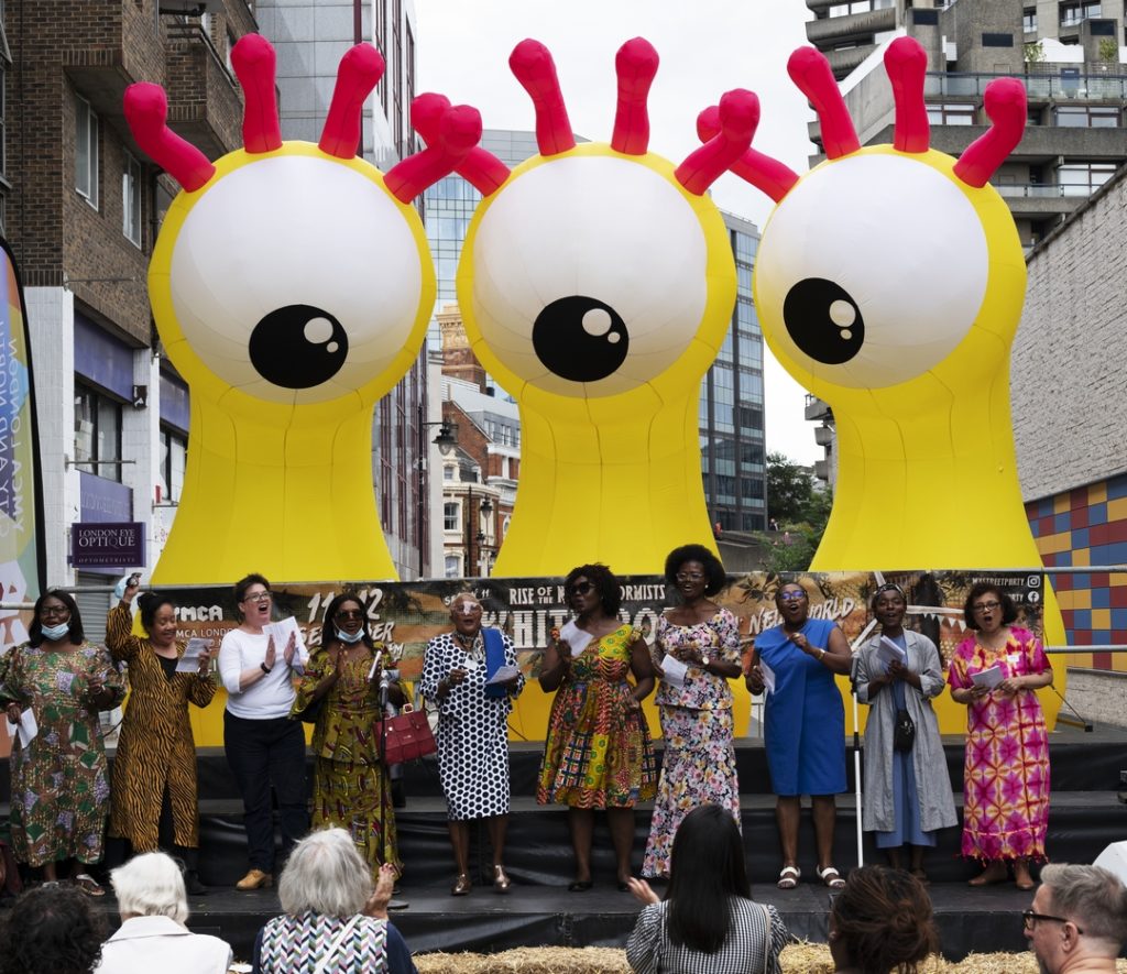 A choise singing Glory Glory Hallelujah in front of inflatable monster Goofs by Filthy Luker at Whitecross Street Party