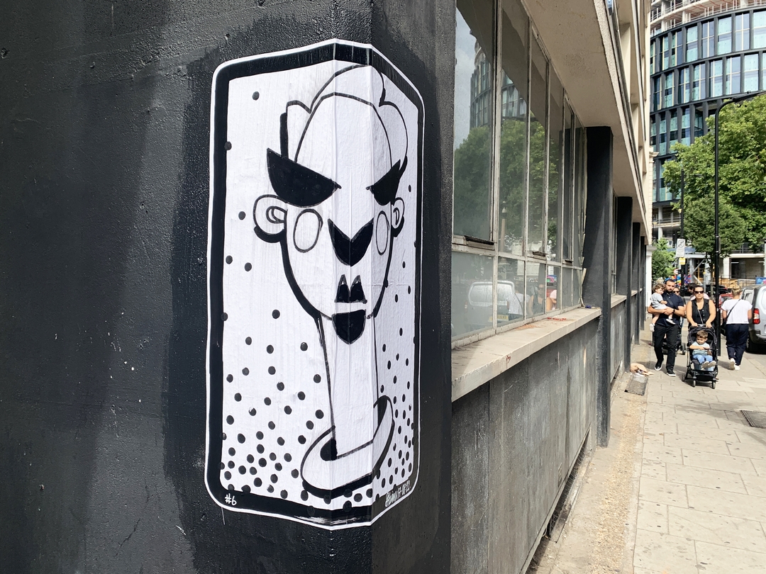 Street art Paste up Cartoon with sunglasses matched by womana in background with sunglasses by Stephen Haim