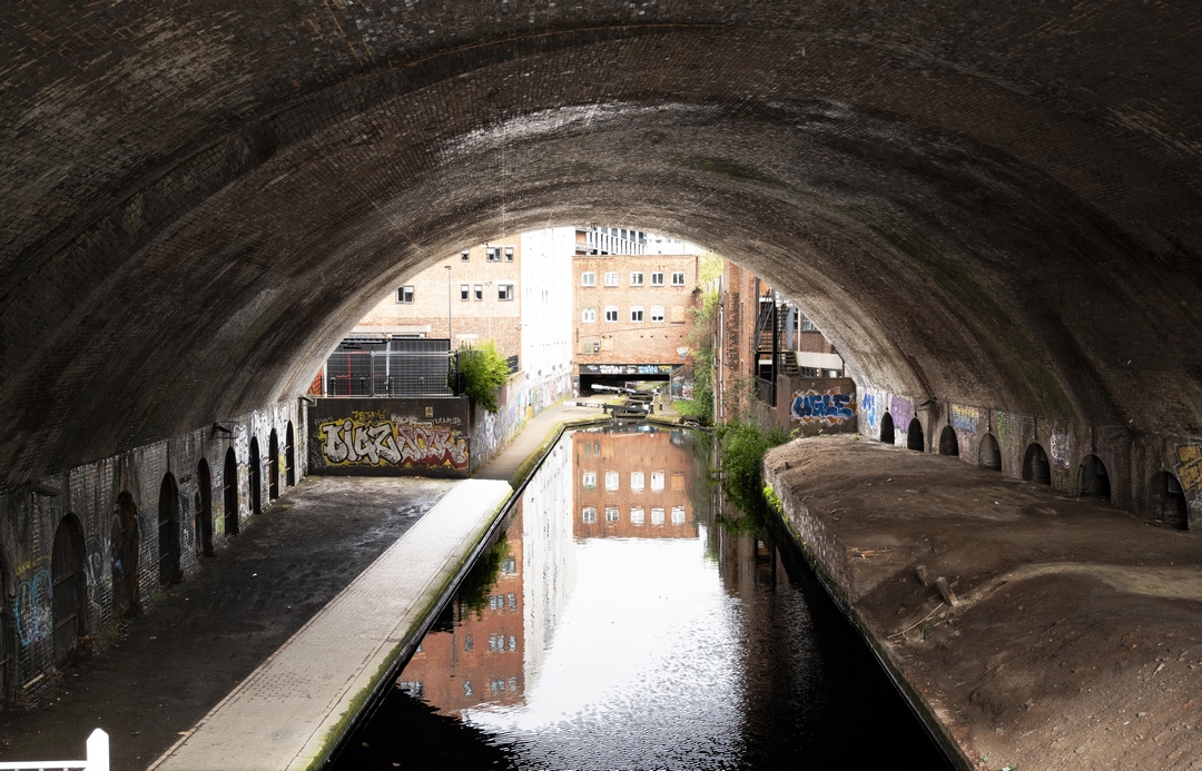 Post industrial heritage shot with The Birmingham & Fazeley Canal goes through a brick lined arch in Birmingham