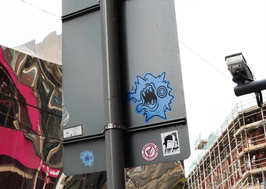 Sticker artists Werck1 and Lisk Bot on a traffic sign in Birmingham