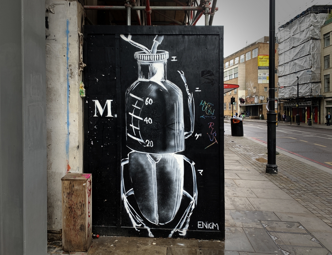 Surreal Street art painting depicting a large beetle mad eof a heart and a medicine bottle on Shoreditch High Street by Japanese street artist Enigma