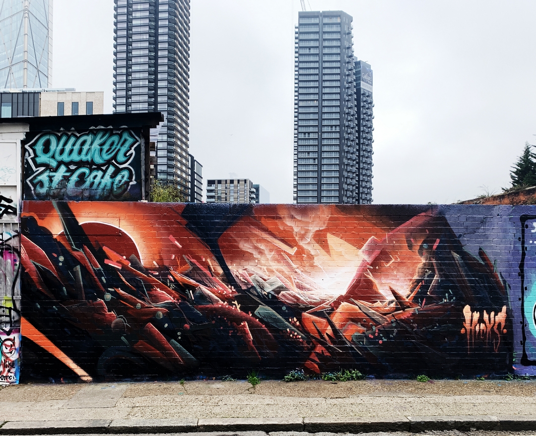 a spectacular mural in Shoreditch London depicting a volcanic rocky landscape with fiery red skies by street artist Ed Hicks