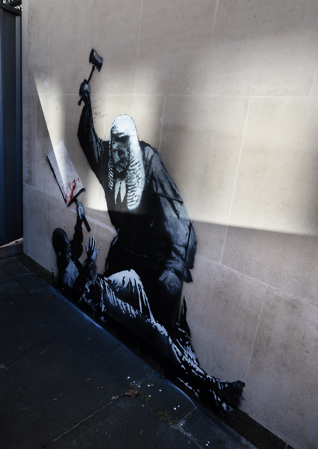 Stencil street art by banksy of a judge beating a protestor with a gavel at London's Royal Courts of Justice